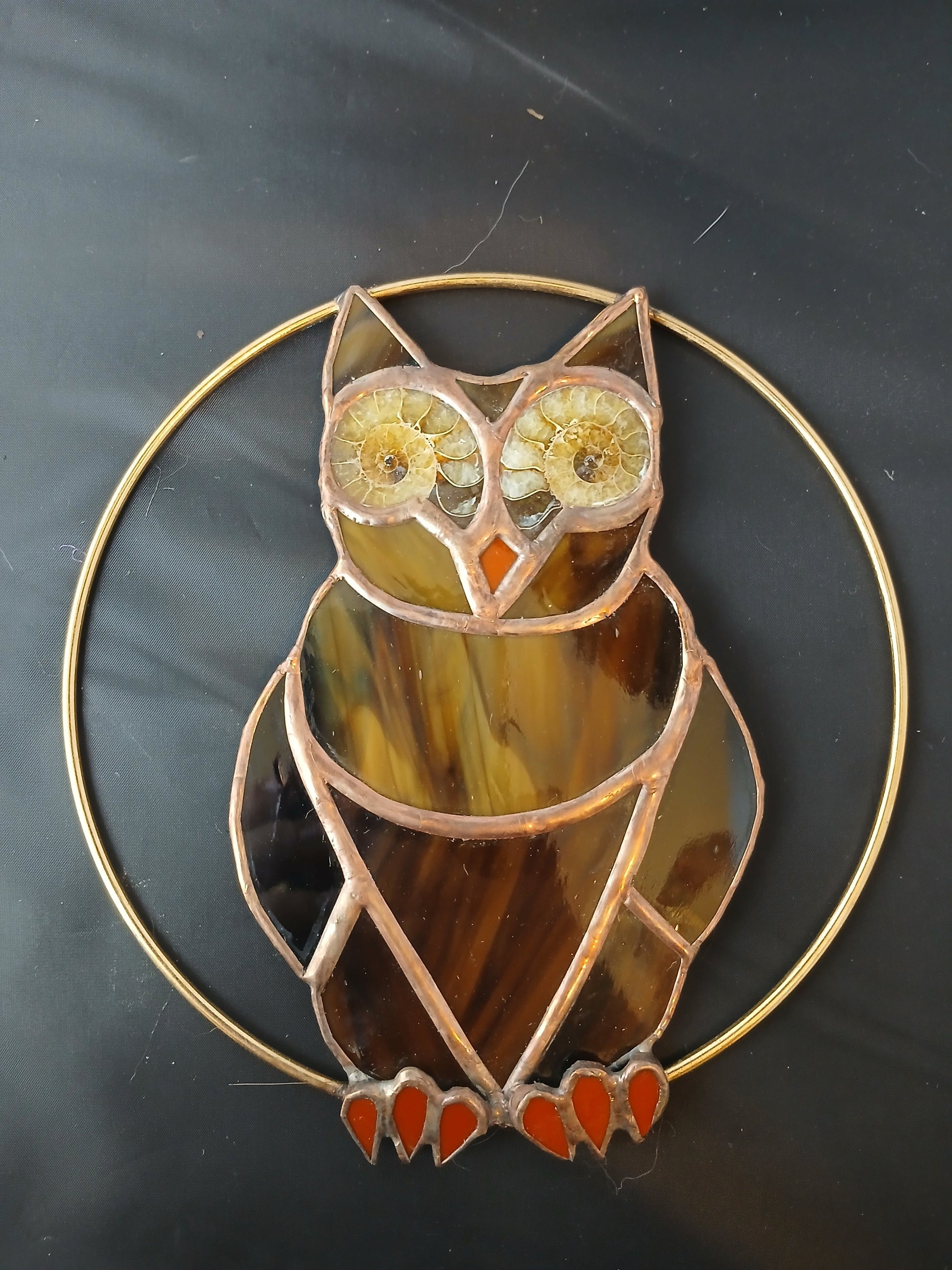 Decorative owl-shaped stained glass piece on a dark background
